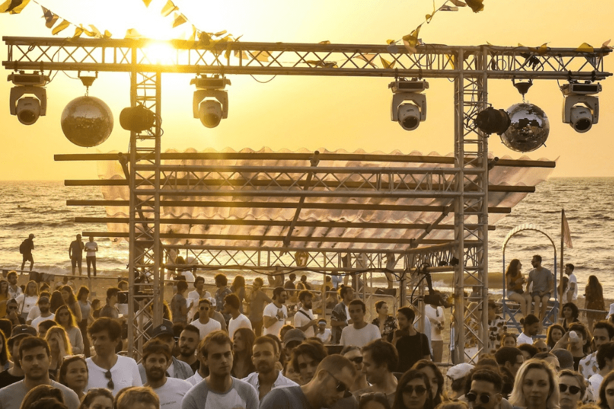 scène musicale sur la plage avec foule coucher du soleil 