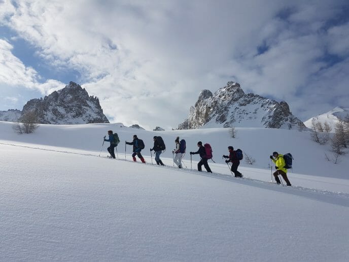 un groupe de personnes fait des raquettes en montagne