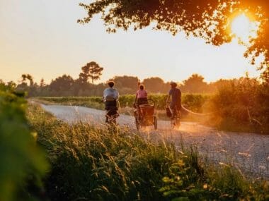 famille vélo coucher de soleil